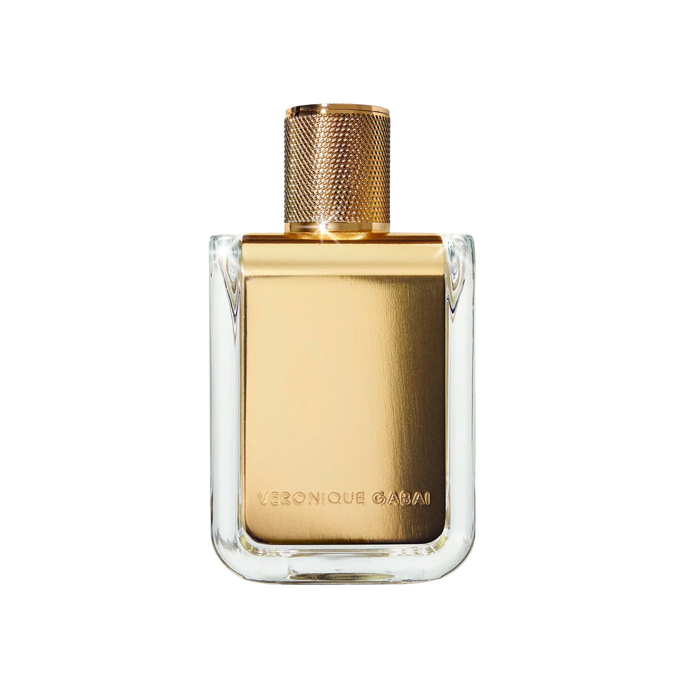 Square glass perfume bottle with gold metal label printed with 'Veronique Gabai' and a gold cap on a white background. 