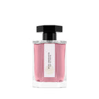 Pink perfume bottle with a white label, pink liquid and black cap on a white background